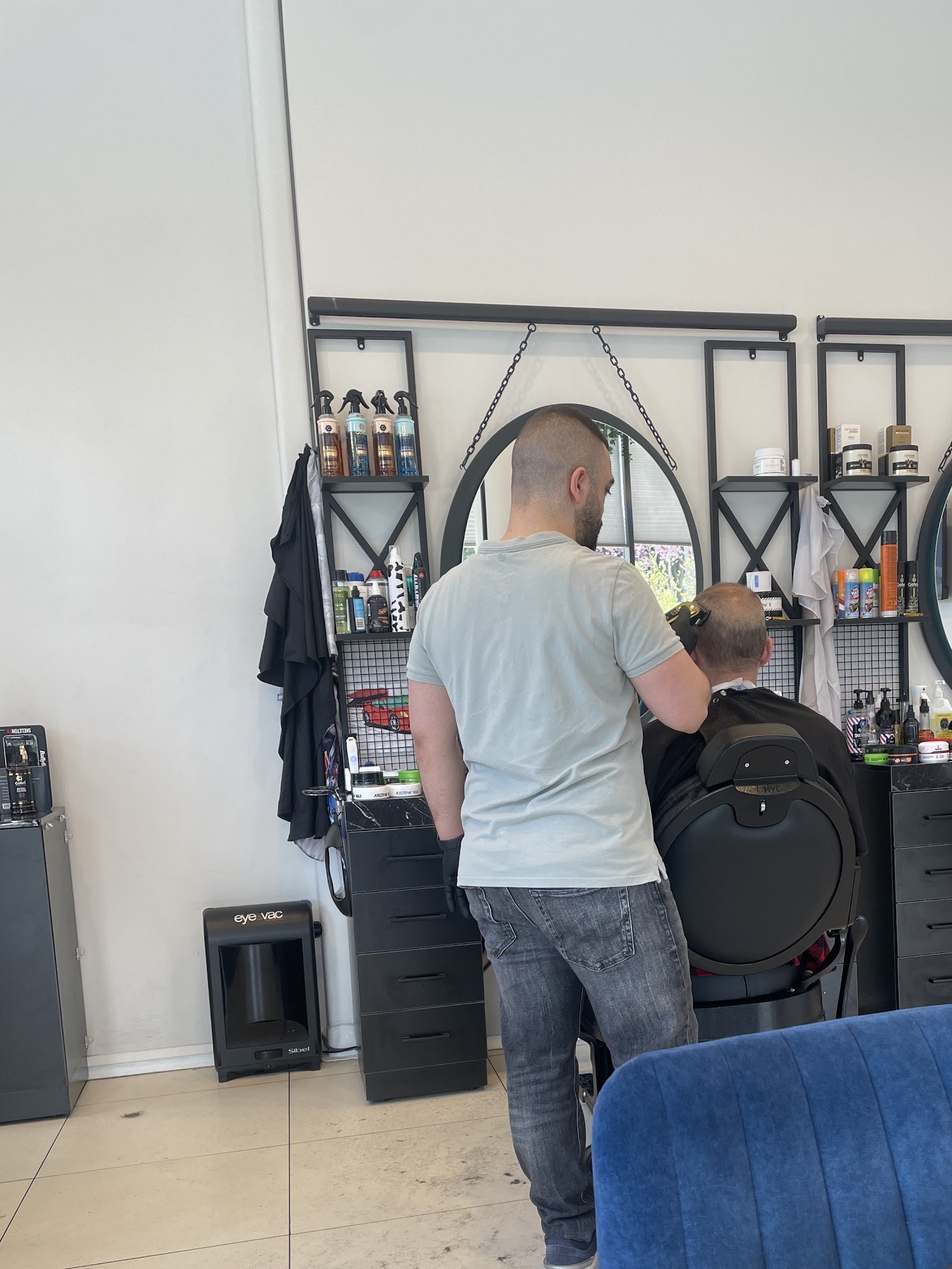 Een kapper knipt een klant aan zijn werkplek in de salon